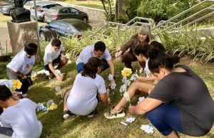 Alunos plantam flores figurativas em alusão ao Maio Laranja